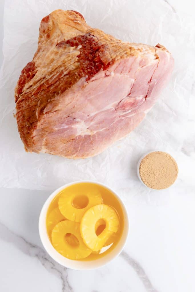 Spiral ham, brown sugar and bowl of pineapple slices.