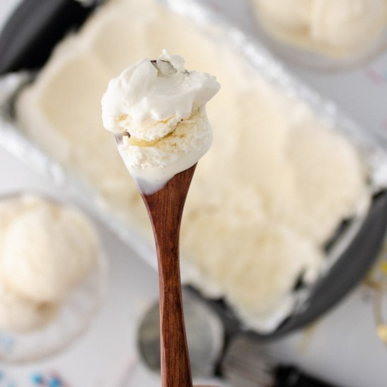 Wooden spoon with scoop of vanilla ice cream.