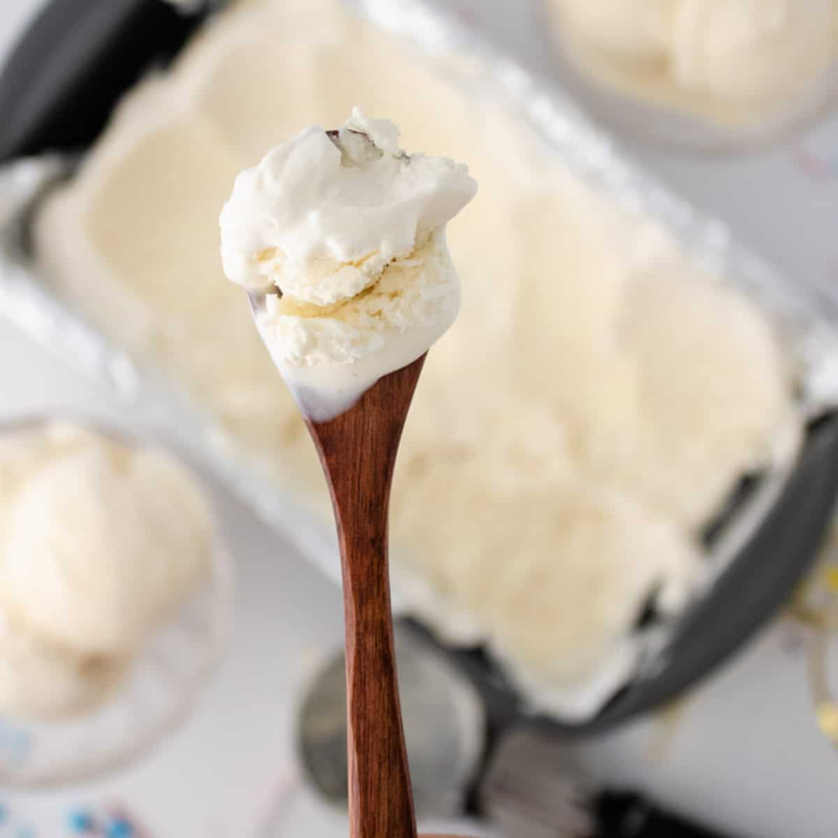 Wooden spoon with scoop of vanilla ice cream.