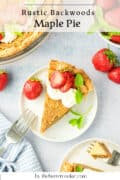 A slice of maple pie topped with whipped cream, strawberry slices, and mint leaves sits on a white plate, surrounded by fresh strawberries and a pie dish. Text reads: Rustic Backwoods Maple Pie by thebuttercookie.com.