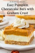 A slice of pumpkin cheesecake bar with graham cracker crust, topped with whipped cream, is served on a white plate. Text above reads, Easy Pumpkin Cheesecake Bars with Graham Crust.
